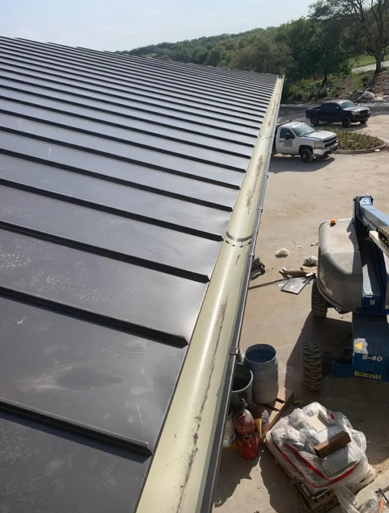 Standing seam panel and gutter detail on a metal roofing jobsite in Macedon